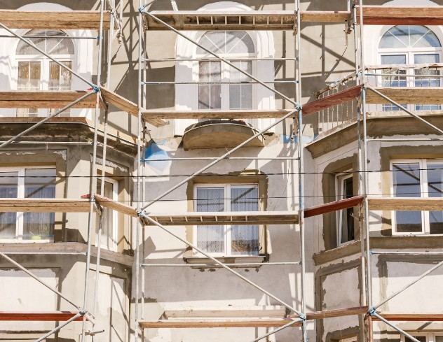 Andamio en edificio de viviendas en Mallorca Andamio montado ante un edificio con balcones y ventanas arqueadas: rehabilitación integral de edificios