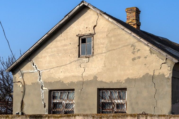 Grietas estructurales en fachadas en Mallorca Fachada de una casa con grietas profundas y el revoco desprendido: patologías de fachada