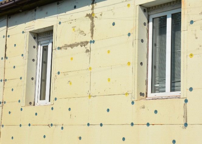 Placas de aislamiento fijadas con tacos sobre la fachada, alrededor de las ventanas: tratamiento de los huecos de ventana